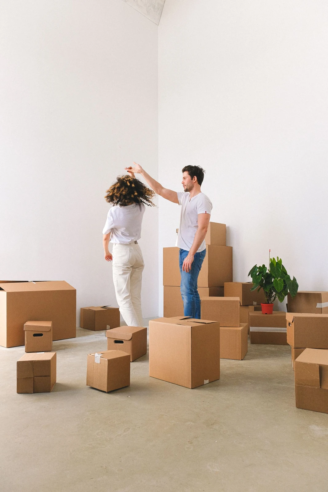 A couple dancing among moving boxes in their new home
